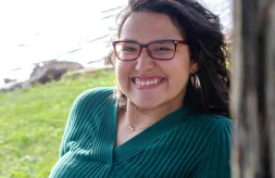 A close up portrait of Petra Petty smiling while sitting outdoors