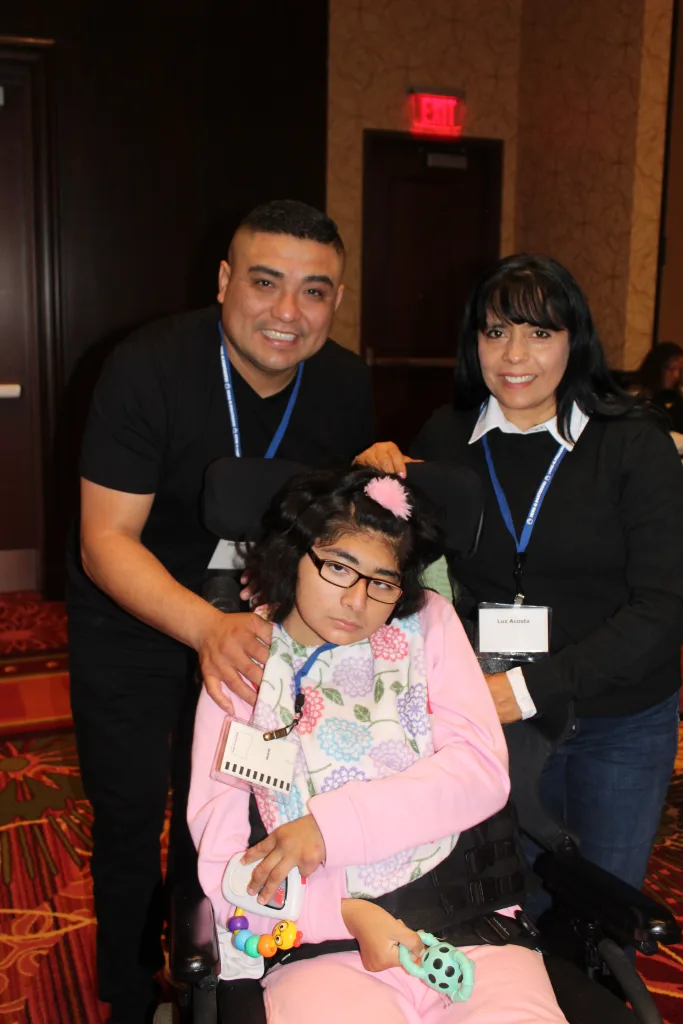 DSCC participant Ariana Diaz sits in her wheelchair with her parents, Luz and Edgar, beside her at the Illinois Statewide Transition Conference